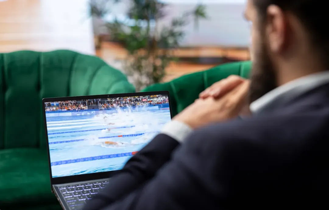 A businessman watching a live streaming video on his laptop
