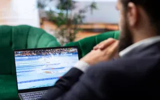 Ein Geschäftsmann schaut sich einen Live-Stream auf seinem Laptop an