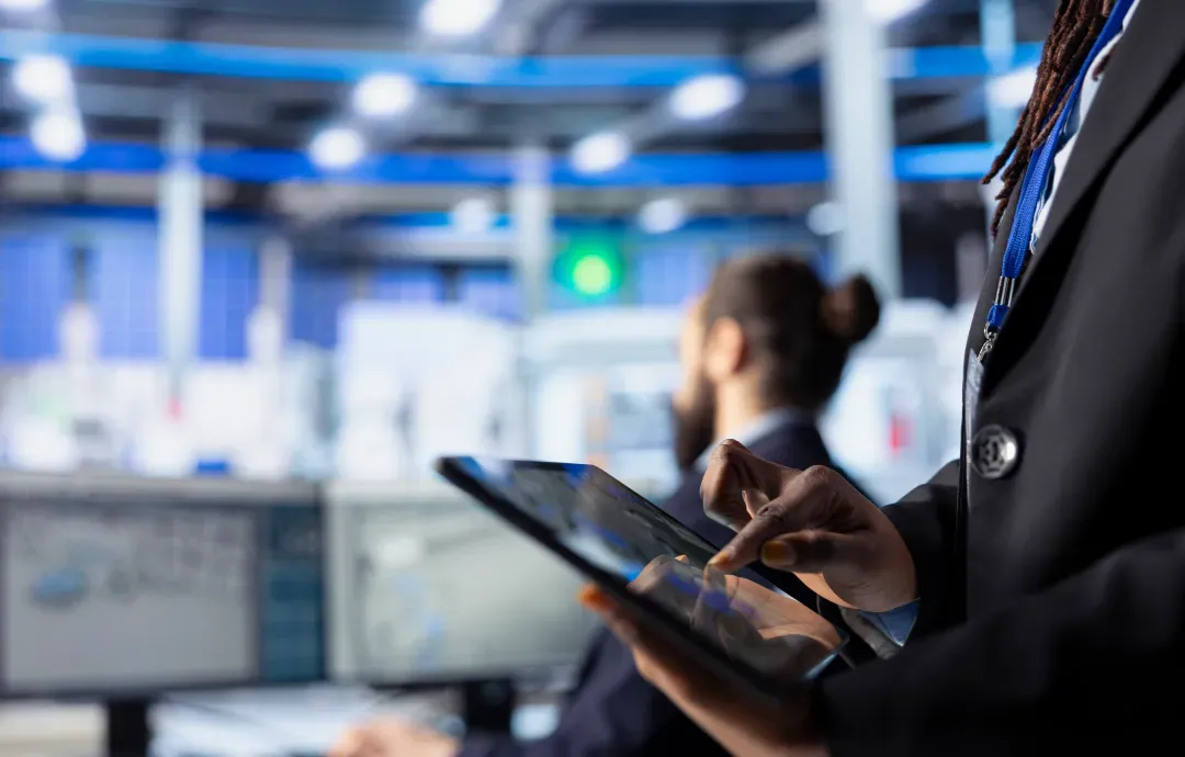 A professional using a tablet in a high-tech industrial control room