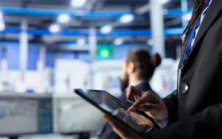 A professional using a tablet in a high-tech industrial control room