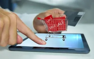 Man playing tablet with shopping cart