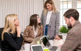 A female manager talking with colleagues at an office desk